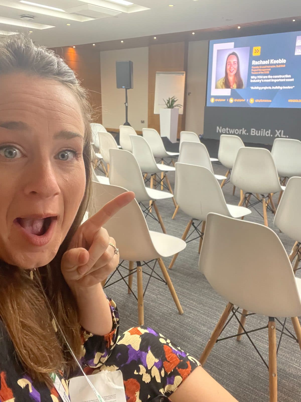 Rachael pointing at her name on the speaker screen before her Big 5 talk