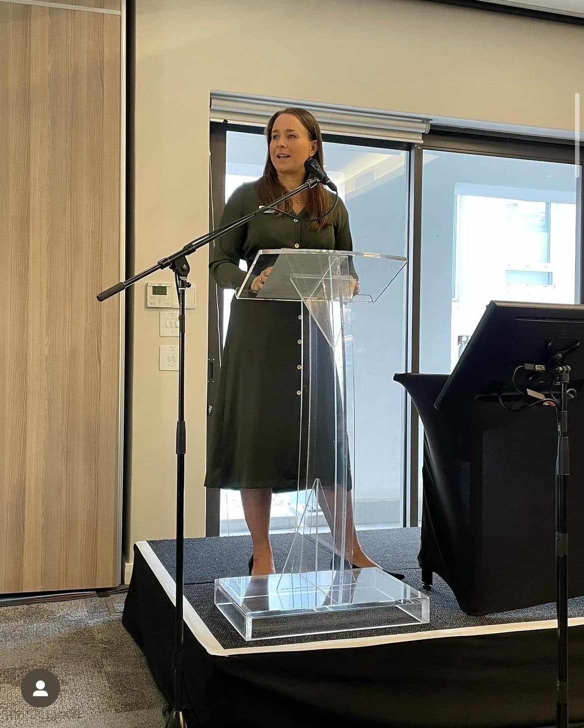 Rachael speaking from a lectern at an industry event